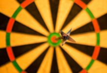 The Role of Accountability in Reaching Your Goals black dart pink attach on yellow green and red dart board