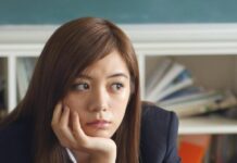 Journey to Wellness: Visual Narratives of Personal Transformation woman holding chin sitting beside table in room