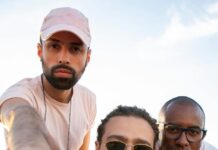 Travel Tales: Exploring the World Through Captivating Visuals joyful trendy young diverse guys taking self portrait on roof