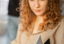 Inspirational Success Stories: Short Tales of Triumph and Achievement young woman writing in notebook in comfortable armchair