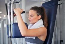 Health and Wellness Transformations: Stories of Personal Growth and Achievement young determined sportswoman doing exercise on weight machine in modern sports club