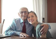 Family and Relationships: Heartwarming Stories of Love, Growth, and Connection positive senior man in formal wear and eyeglasses hugging with young lady while sitting at table