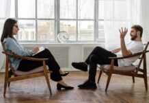 The Connection Between Mindfulness and Mental Health: Promoting Emotional Well-Being person in black pants and black shoes sitting on brown wooden chair