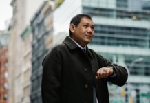 Setting Realistic Deadlines: Strategies for Meeting Your Goals on Time elegant ethnic businessman checking time on wristwatch on city street
