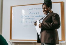 Career Mentoring: Finding and Nurturing Relationships for Professional Growth crop cheerful black female teacher standing near whiteboard in classroom