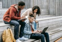 Academic Excellence: Students and Scholars Share Their Academic Success Stories cheerful diverse students sharing laptop while studying on street stairs