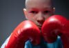 Triumph Over Tragedy: Stories of Resilience and Strength in the Face of Challenges portrait of boy wearing boxing gloves