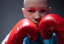 Triumph Over Tragedy: Stories of Resilience and Strength in the Face of Challenges portrait of boy wearing boxing gloves