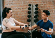 Embracing Self-Discovery: Exploring Your Strengths and Weaknesses a personal trainer next to a woman exercising on rowing machine