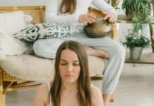 Creating a Mindful Home Environment: Tips for Cultivating Tranquility woman meditating with burning sage smudge stick