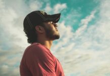 Introduction to Mindfulness: A Beginner’s Guide to Living in the Present Moment man wearing black cap with eyes closed under cloudy sky