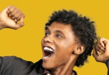 Motivation delighted black man raising hands in fists in excitement