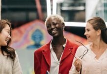 Career Development diverse successful businesswomen smiling and walking together in modern workplace