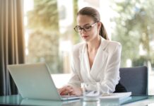 Smart Goals Meaning concentrated female entrepreneur typing on laptop in workplace