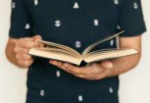 Personal Development Courses faceless man in tee shirt paging interesting book