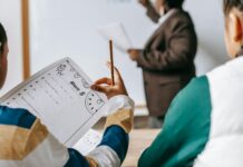 List of Professional Development Topics diverse crop pupils sitting at desk against black teacher