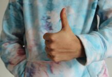 Who is the Best Motivator of Life? a person in tie dye sweater doing thumbs up