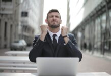 Who is a Successful Man? man in black suit sitting on chair beside buildings