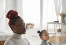 What is the ABCD of Mindfulness? relaxed black woman with little daughter practicing lotus pose at home