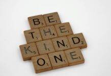 The Power of Kindness: How Small Acts Can Create Big Changes brown wooden blocks on white surface