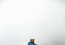 Inspire Mind Journey: Unlocking Your True Potential a man wearing jacket sitting on the rock